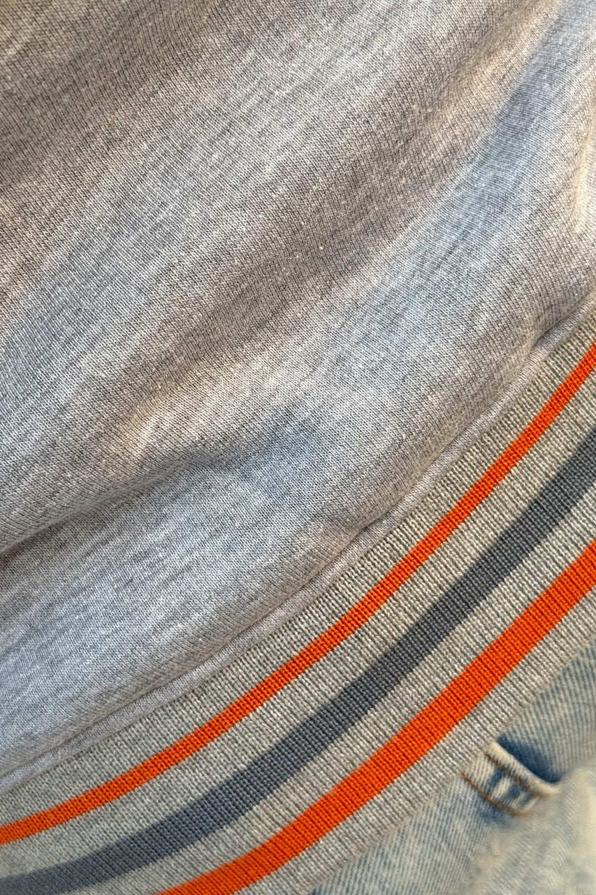 The jacket's edges are decorated with gray and orange stripes